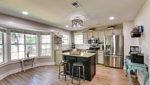 A modern kitchen with a central island, stainless steel appliances, and large windows. - Charming Coastal Home: 6 Mi to Choctawhatchee Bay! (Niceville)