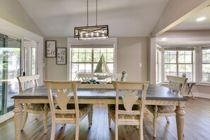 A dining room with a large table and chairs, a chandelier, and framed artwork on the walls. - Charming Coastal Home: 6 Mi to Choctawhatchee Bay! (Niceville)