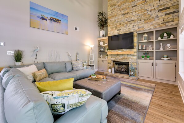 A modern living room with a sectional sofa, a fireplace, and a flat-screen TV. - Charming Coastal Home: 6 Mi to Choctawhatchee Bay! (Niceville)