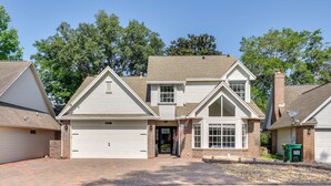 A two-story house with a central entrance, a garage, and a satellite dish. - Charming Coastal Home: 6 Mi to Choctawhatchee Bay! (Niceville)