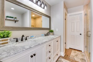 A bathroom with a large mirror, two sinks, and a shower area. - Charming Coastal Home: 6 Mi to Choctawhatchee Bay! (Niceville)