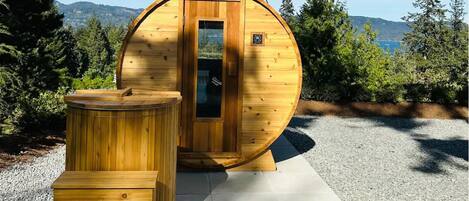 Eine Holz-Sauna mit Tür, einer Sitzbank und einem kleinen Tisch.