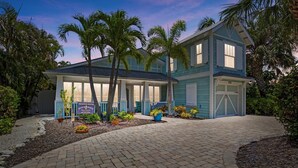 A two-story house with a covered porch, a garage, and a paved driveway.