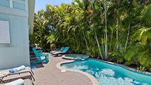 A pool area with lounge chairs and a tiled deck.