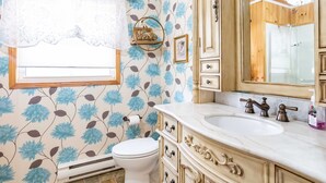 A bathroom with a toilet, sink, and mirror.