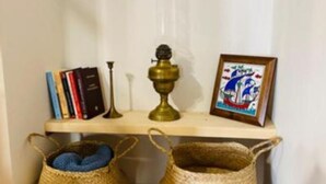 Een plank met boeken, een messing lamp, een ingelijst beeld en twee gevlochten manden.