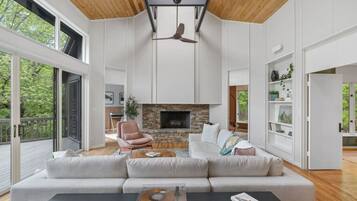 A modern living room with a stone fireplace, a large sofa, and a coffee table.
