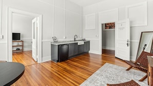 A modern kitchen with a black dishwasher, grey cabinets, and a white countertop. - The McKey (Valdosta)