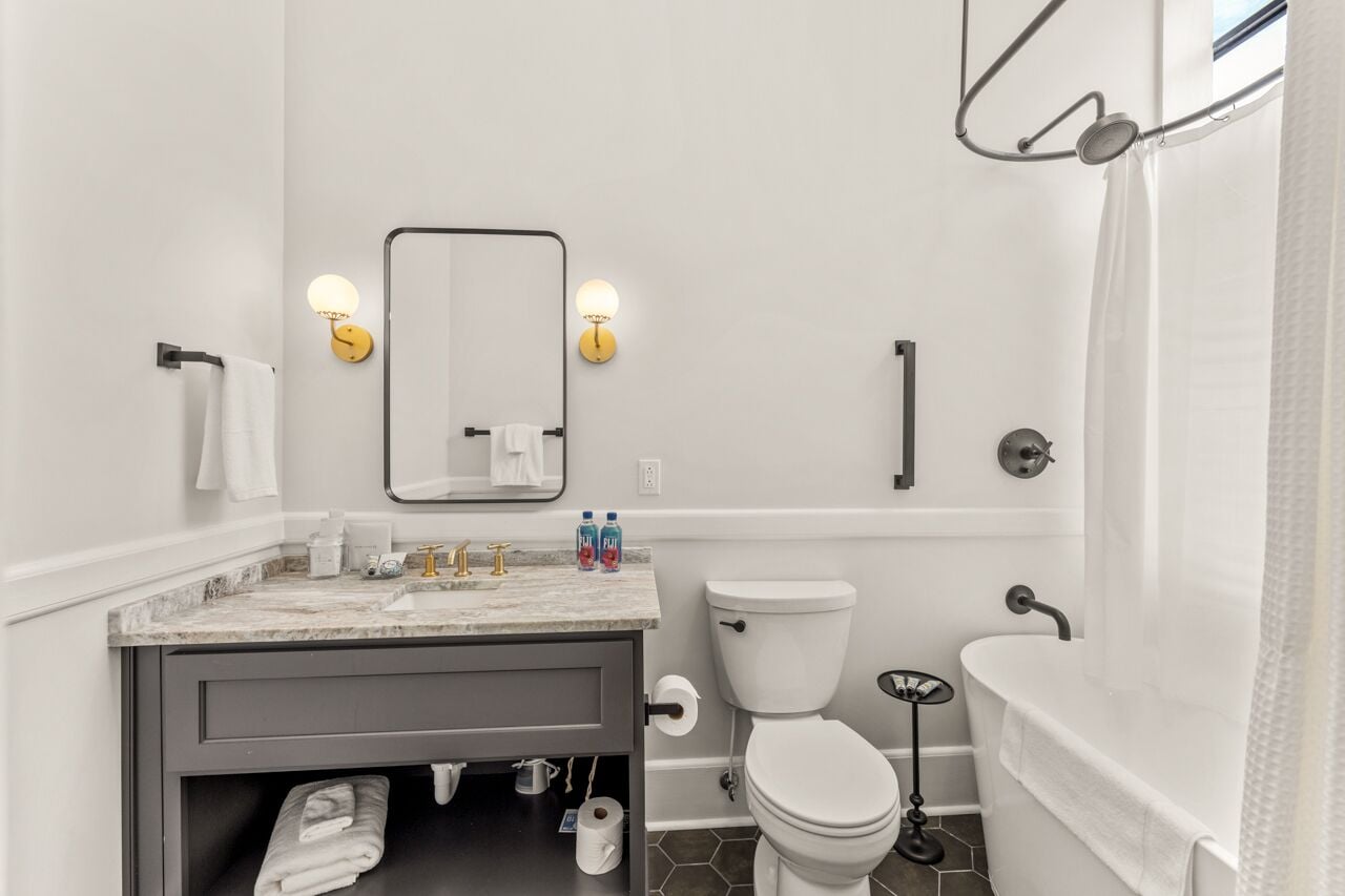 Ein modernes Badezimmer mit Marmorwaschtisch, Toilette, Badewanne und Dusche.