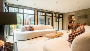 A modern living room with a white sofa, a wooden coffee table, and a fireplace. - Huyze Ter Bercken with swimming pond by Interhome (De Haan)