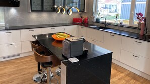 Una cocina moderna con encimera negra, armarios blancos y ventana con vistas al exterior.