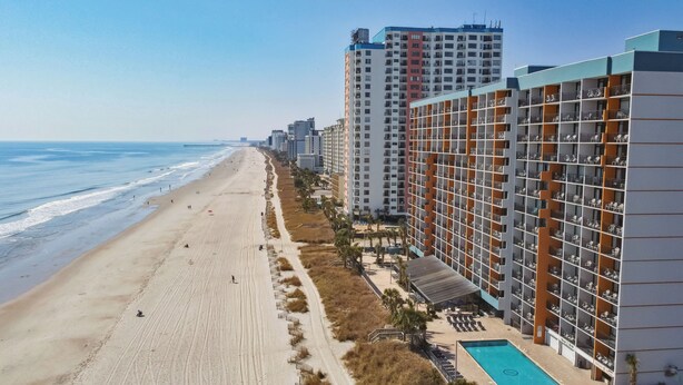 A beachfront hotel with a pool, multiple floors, and a beach view. - Ocean View King Suit Heated Pools Myrtle Beach  (Myrtle Beach)