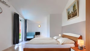 Een moderne slaapkamer met een groot bed, nachtkastjes, een televisie en een schilderij aan de muur.
