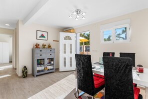 A dining area with a table, chairs, and a view of the outdoors. - Villa Campanilla - Plusholidays (Calpe)