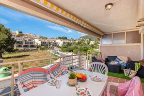 Ein Balkon mit Esstisch, Sitzgelegenheiten im Freien und Blick auf eine Wohngegend.