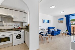 A modern apartment with a kitchen, dining area, and living room.