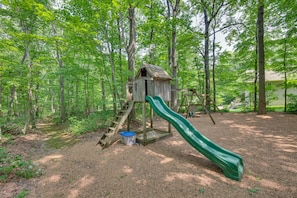 Children can play in the playground with a wooden playhouse and slide.