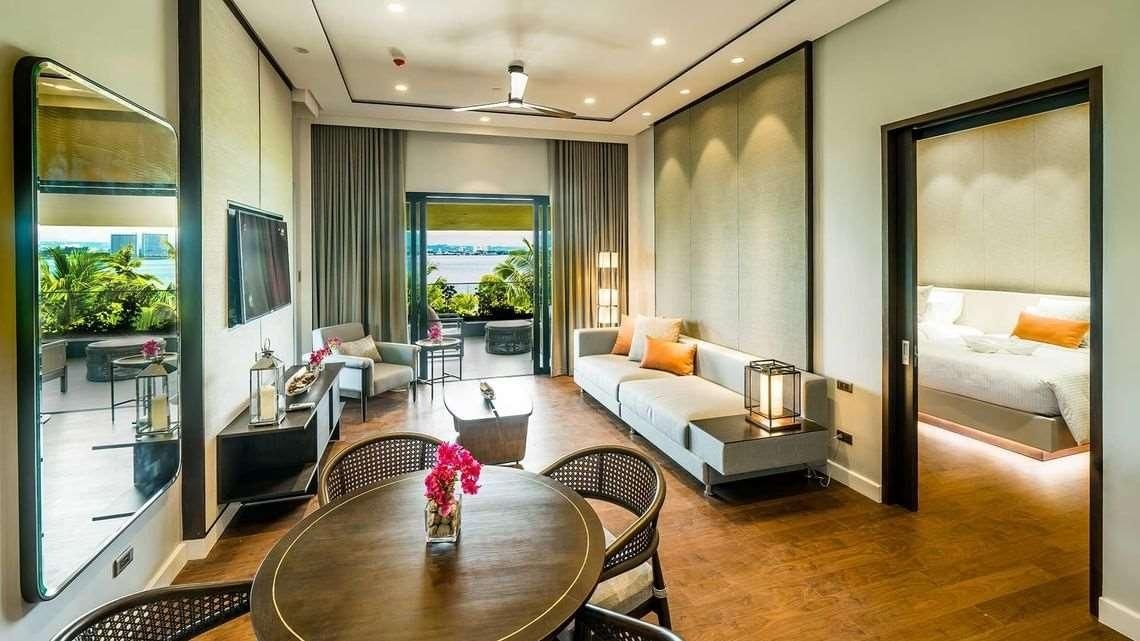 Una habitación de hotel moderna con sofá, mesa de comedor y cama.