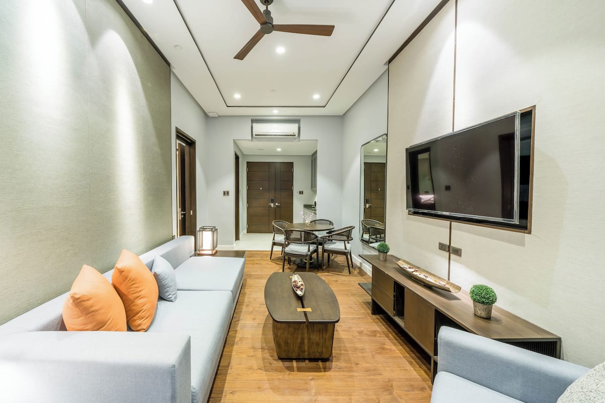 Uma sala de estar moderna com sofá, mesa de centro e televisão.