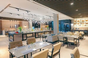 A modern restaurant with a central bar area, dining tables, and chairs.