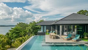A modern house with a pool, outdoor seating, and a view of the sea. - Discovery Samal (Samal)