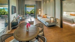 A modern hotel room with a balcony, a sofa, a dining table, and a bed. - Discovery Samal (Samal)
