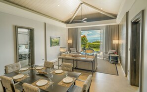 Une chambre d’hôtel avec un coin repas, un balcon avec vue et un ventilateur de plafond.