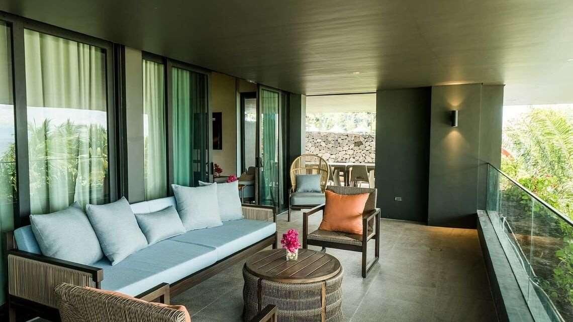 A modern living room with a sofa, chairs, and a small table.