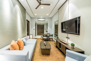 Ein modernes Wohnzimmer mit Sofa, Couchtisch und Fernseher.