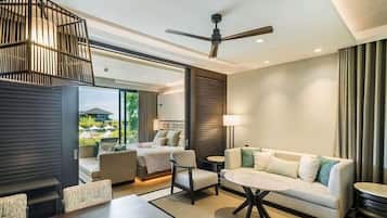 A modern living room with a sofa, armchairs, a coffee table, and a ceiling fan.