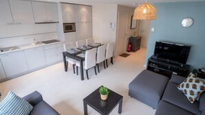 A modern living space with a dining area, kitchen, and seating area. - Apartment Andrei by Interhome (Blankenberge)