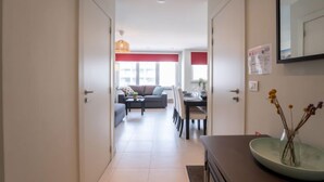 A modern apartment with a dining area, a sofa, and a kitchen in the background. - Apartment Andrei by Interhome (Blankenberge)