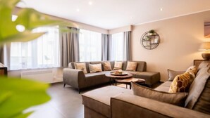 A modern living room with a sectional sofa, a coffee table, and a side table with a lamp. - Philemon with parking by Interhome (Blankenberge)