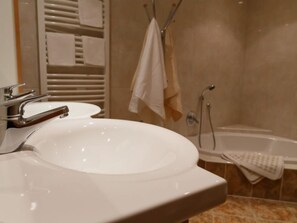 A bathroom with a white sink, a bathtub, and a towel rack.