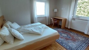 A bedroom with a bed, a desk, and a window. - Löwenzahn by Interhome (Velden am Wörthersee)