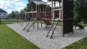 Un’area giochi con diverse strutture di arrampicata, scivoli e una zona coperta.