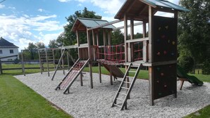 Un parque infantil con varias estructuras para escalar, toboganes y una red de cuerdas.