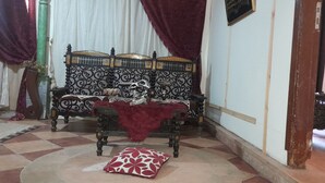 Una habitación tradicional con un sofá estampado, una manta roja y un cojín decorativo.