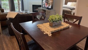 A dining area with a wooden table, chairs, and a small plant centerpiece. - 3 minutes to Dollywood Entrance. Fall Discounts 2bd 2ba Condo.  (Pigeon Forge)