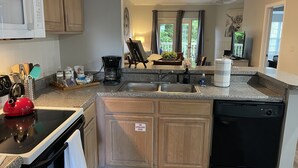 A kitchen with a microwave, stove, sink, and dishwasher. There is a coffee maker and a kettle on the counter. - 3 minutes to Dollywood Entrance. Fall Discounts 2bd 2ba Condo.  (Pigeon Forge)