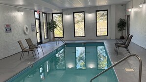 An indoor swimming pool with clear water, surrounded by walls with windows and a ceiling with grid-like panels. - 3 minutes to Dollywood Entrance. Fall Discounts 2bd 2ba Condo.  (Pigeon Forge)
