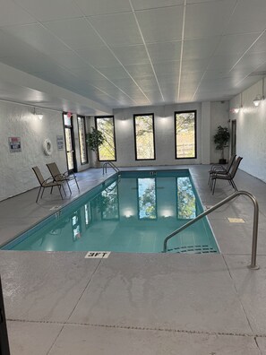 An indoor swimming pool with clear water, surrounded by walls with windows and a ceiling with grid-like panels. - 3 minutes to Dollywood Entrance. Fall Discounts 2bd 2ba Condo.  (Pigeon Forge)