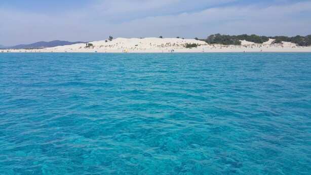 A beach with clear turquoise water and white sand.
