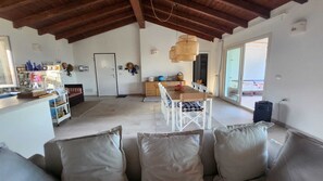 Un amplio salón con techo alto, una mesa de comedor y un sofá.
