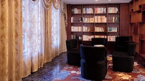 Une bibliothèque avec des étagères, un sol recouvert de moquette et un espace détente avec des fauteuils.