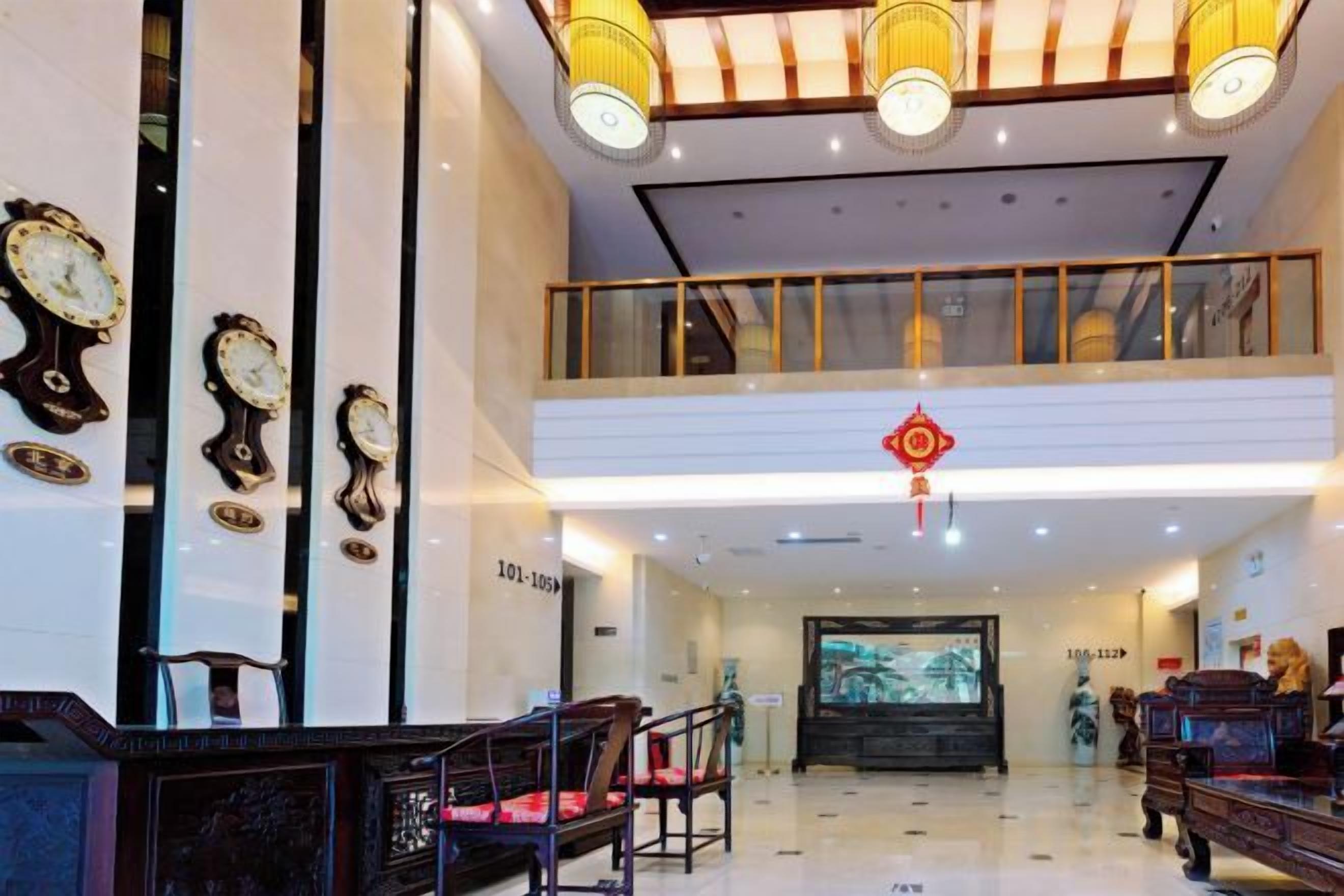 A lobby with a reception desk, seating area, and a large screen displaying a scenic image.