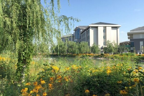 A modern building with a large water feature in front. - Manas County Hotel (Manas County)