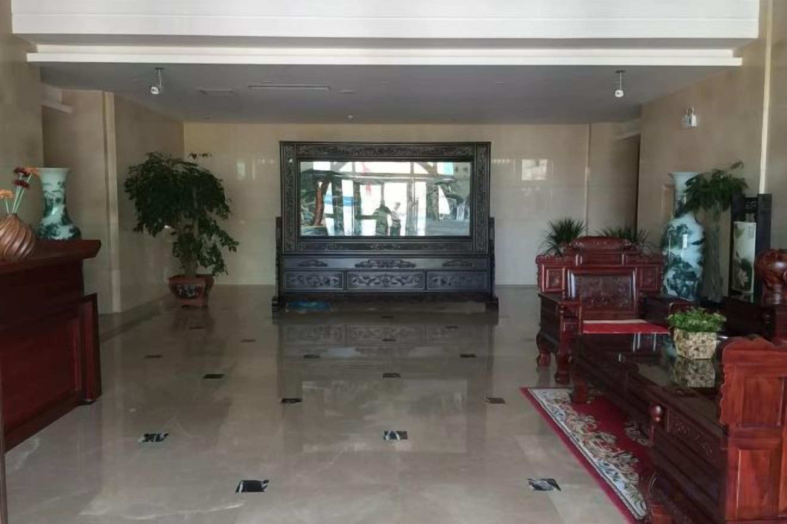 A spacious lobby with a polished floor, a large mirror, and decorative furniture.