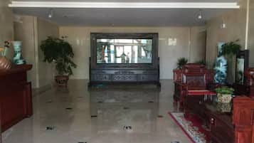 A spacious lobby with a polished floor, a large mirror, and decorative furniture.
