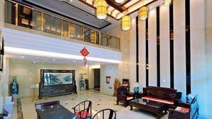 Un hall d’entrée spacieux avec un plafond haut, un grand espace salon et un élément décoratif de style chinois traditionnel.